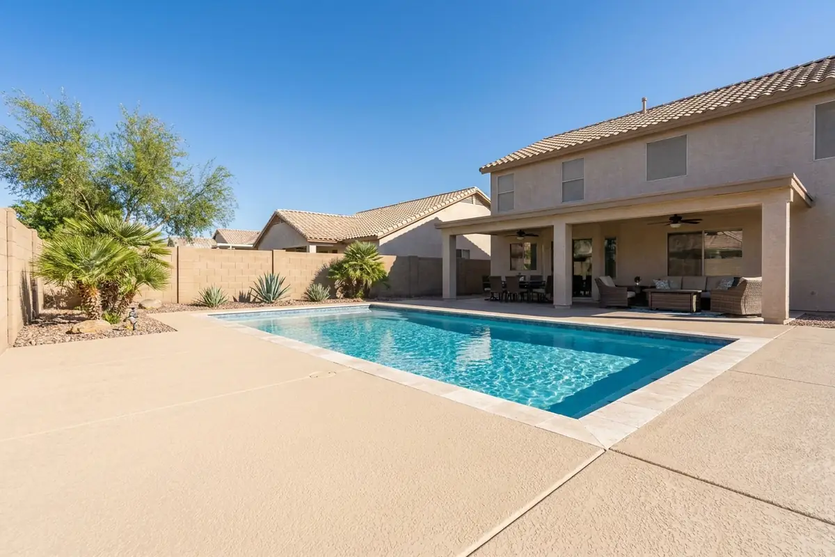 Freshly resurfaced cool deck around a rectangular pool behind a two-story Chandler home